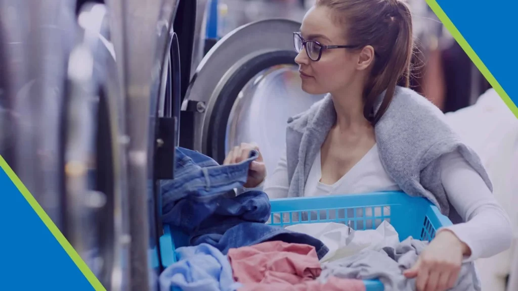 Woman loading laundry into a washing machine in a premier laundry company in Kingston, RI.